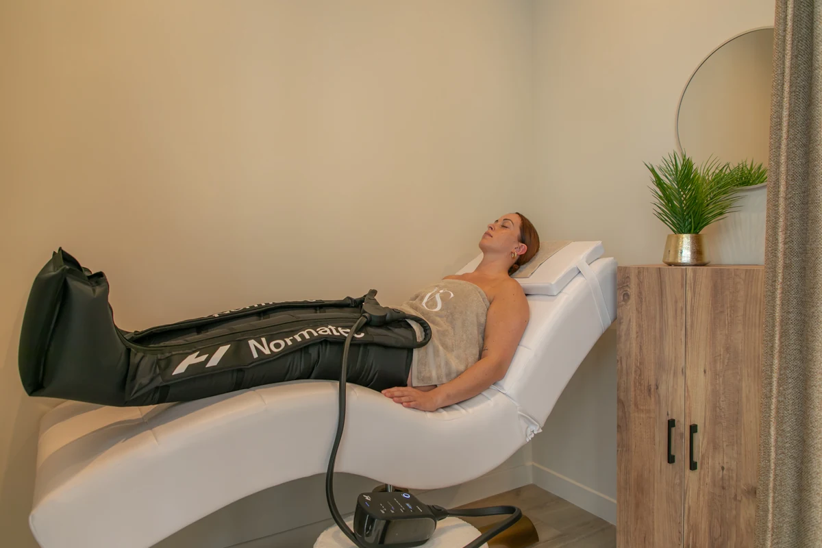 Bottes de pressothérapie pneumatique installées sur les jambes pour un drainage lymphatique — Institut Néa 'Skin à Vincennes