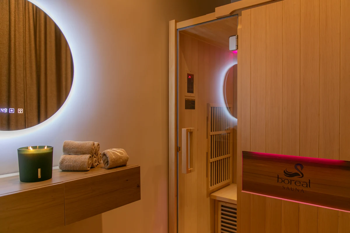 Cabine de sauna infrarouge en bois clair avec banc en cèdre et hublot — Institut Néa 'Skin à Vincennes
